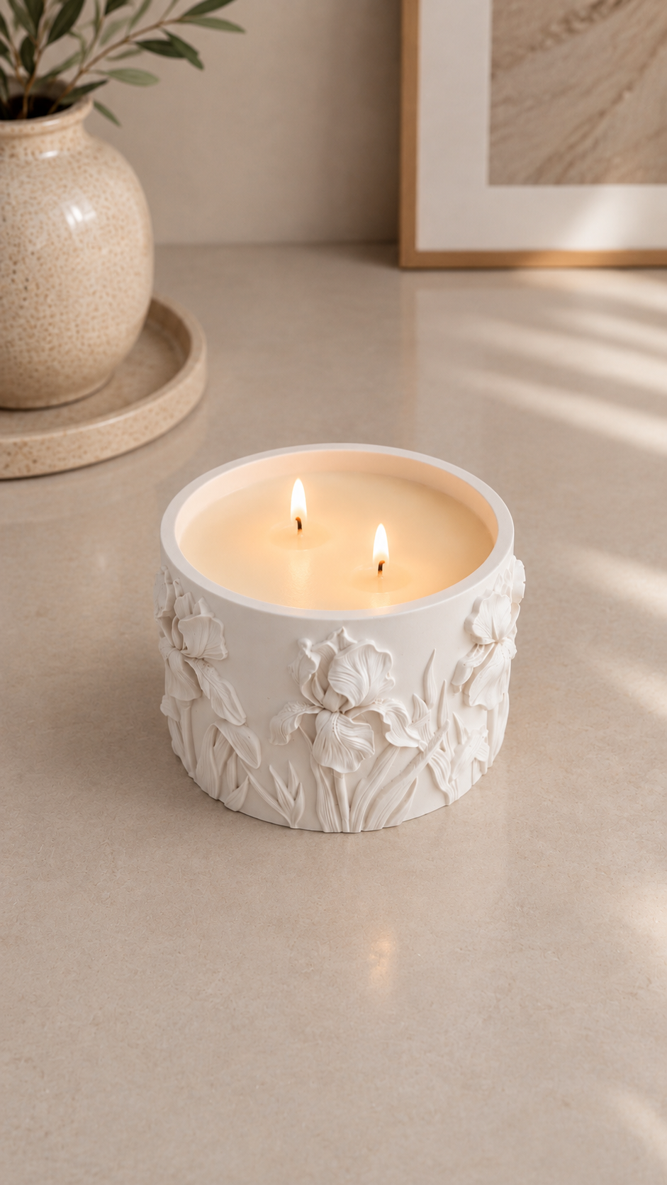 Lit Iris floral candle with two flames in a sculptural botanical Jesmonite vessel