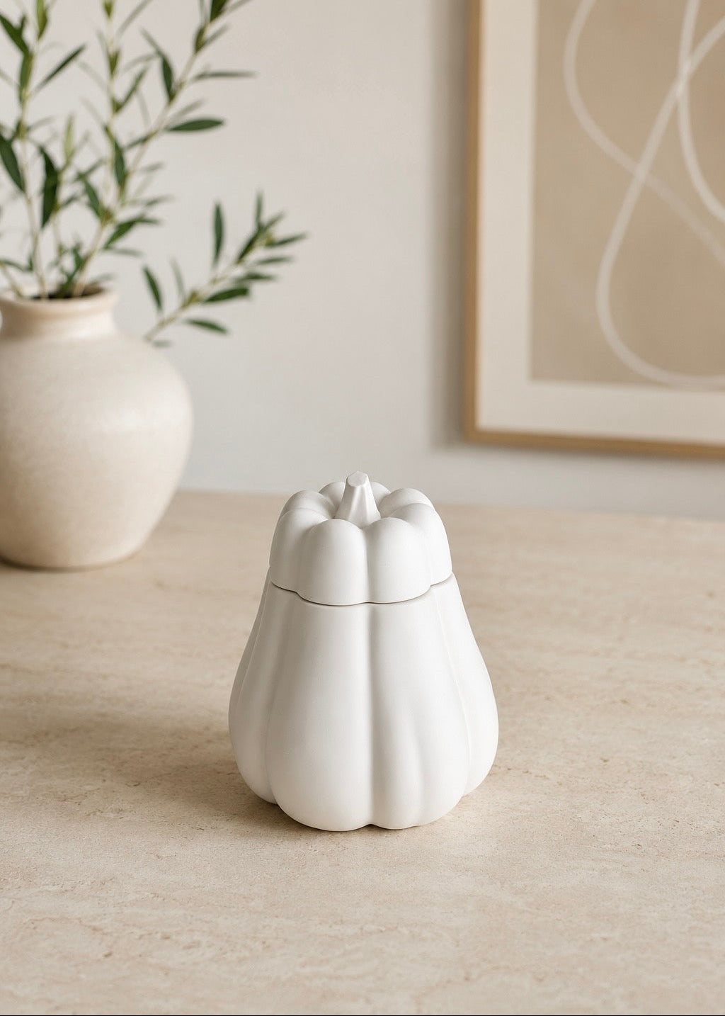 White pumpkin storage pot with lid styled in a modern neutral interior