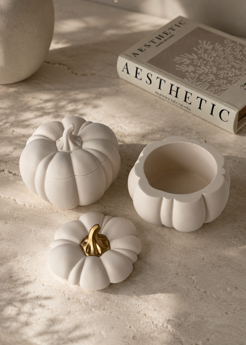 Neutral pumpkin-shaped Jesmonite storage pot with removable lid and decorative gold stem