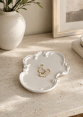 White Rococo vanity tray with gold earrings and perfume on a modern stone table