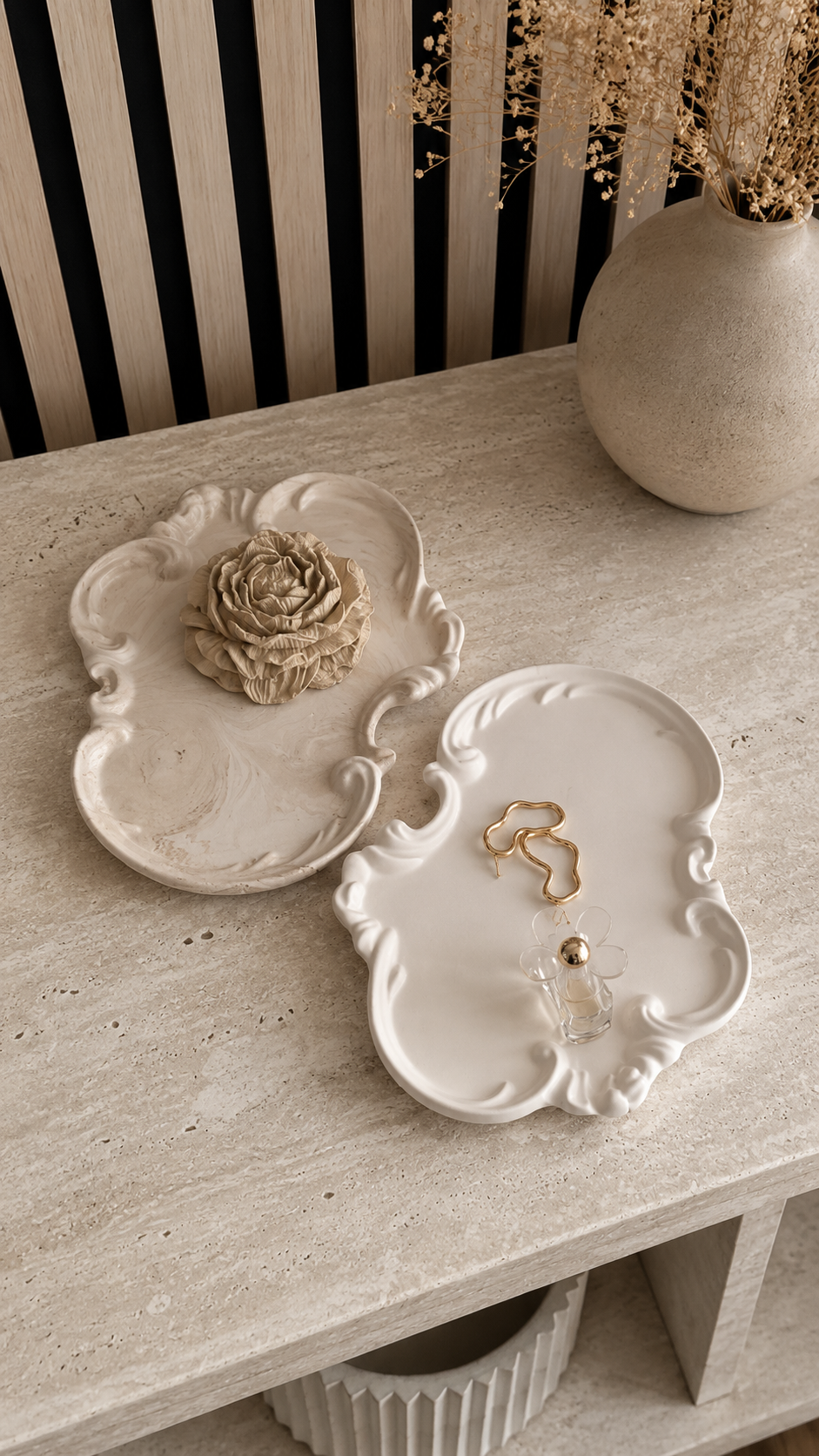 White and marble beige Rococo vanity trays displayed on a modern stone table
