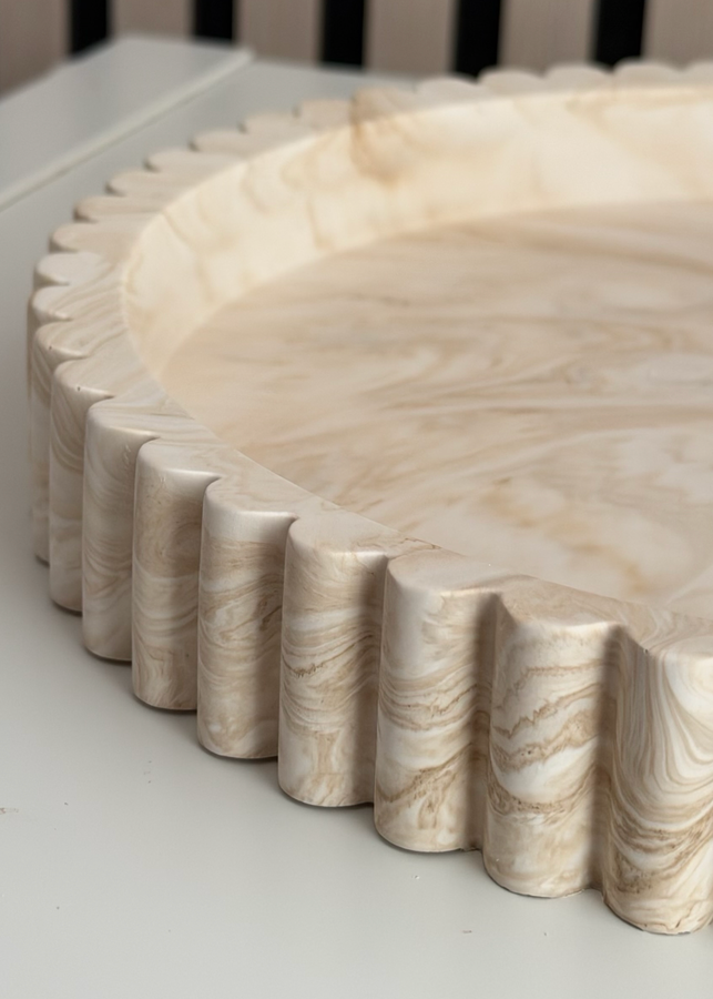 Close-up of the Vela tray scalloped edge and hand-poured cream marble finish