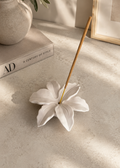 White Lily Flower Incense Holder styled on a decorative book in a modern neutral interior.
