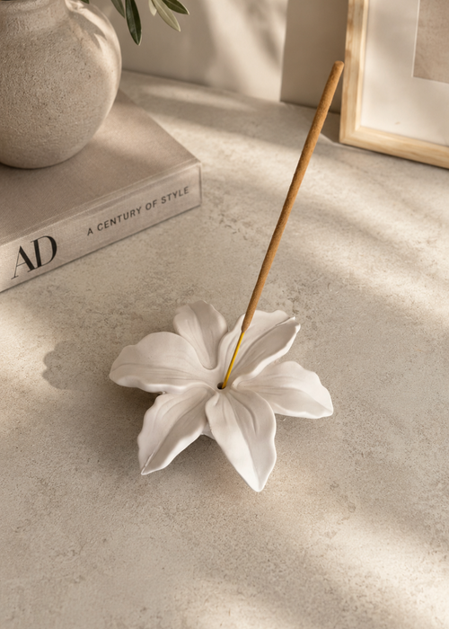 White Lily Flower Incense Holder styled on a decorative book in a modern neutral interior.