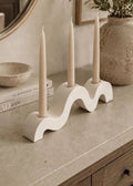 Handmade wave candle holder styled on a neutral stone table in a modern home interior